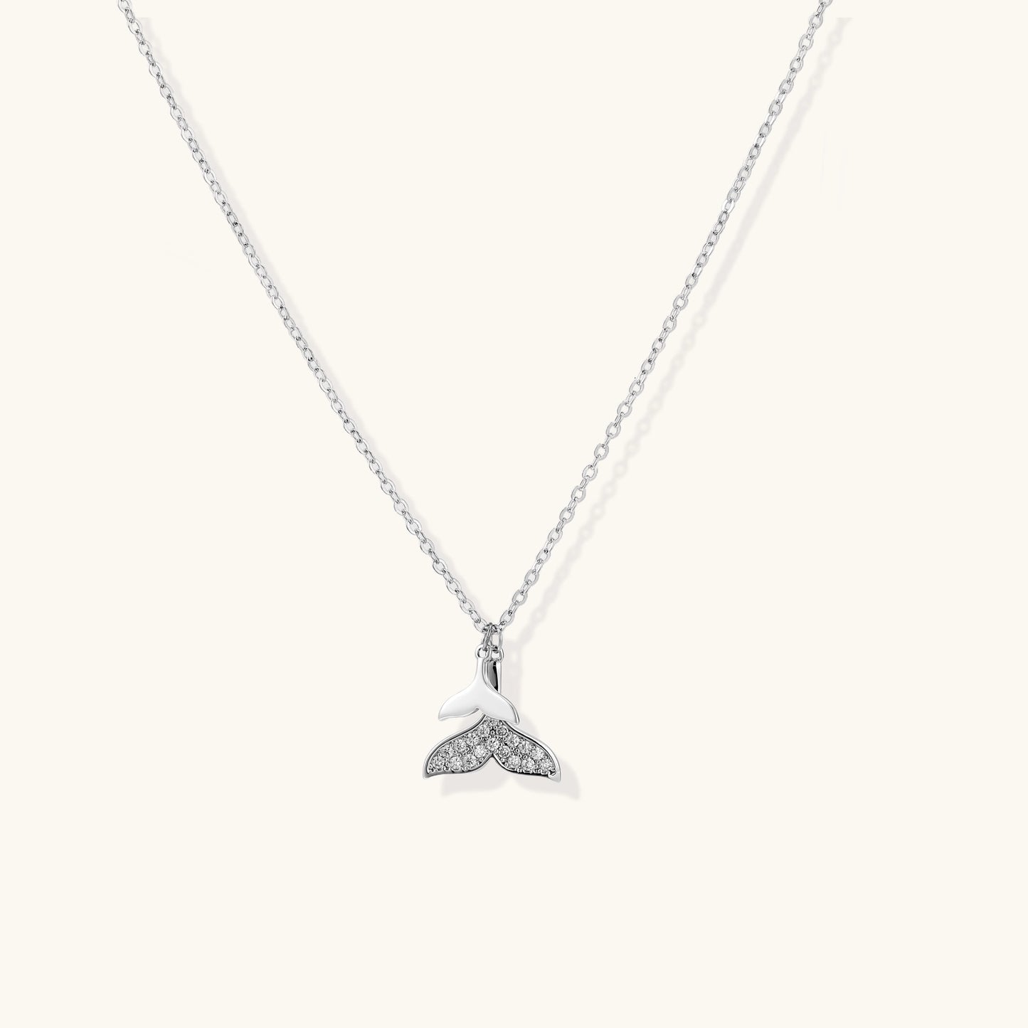 Delicate 14K gold-plated whale tail pendant necklace with sparkling crystal details on fine chain against white background.