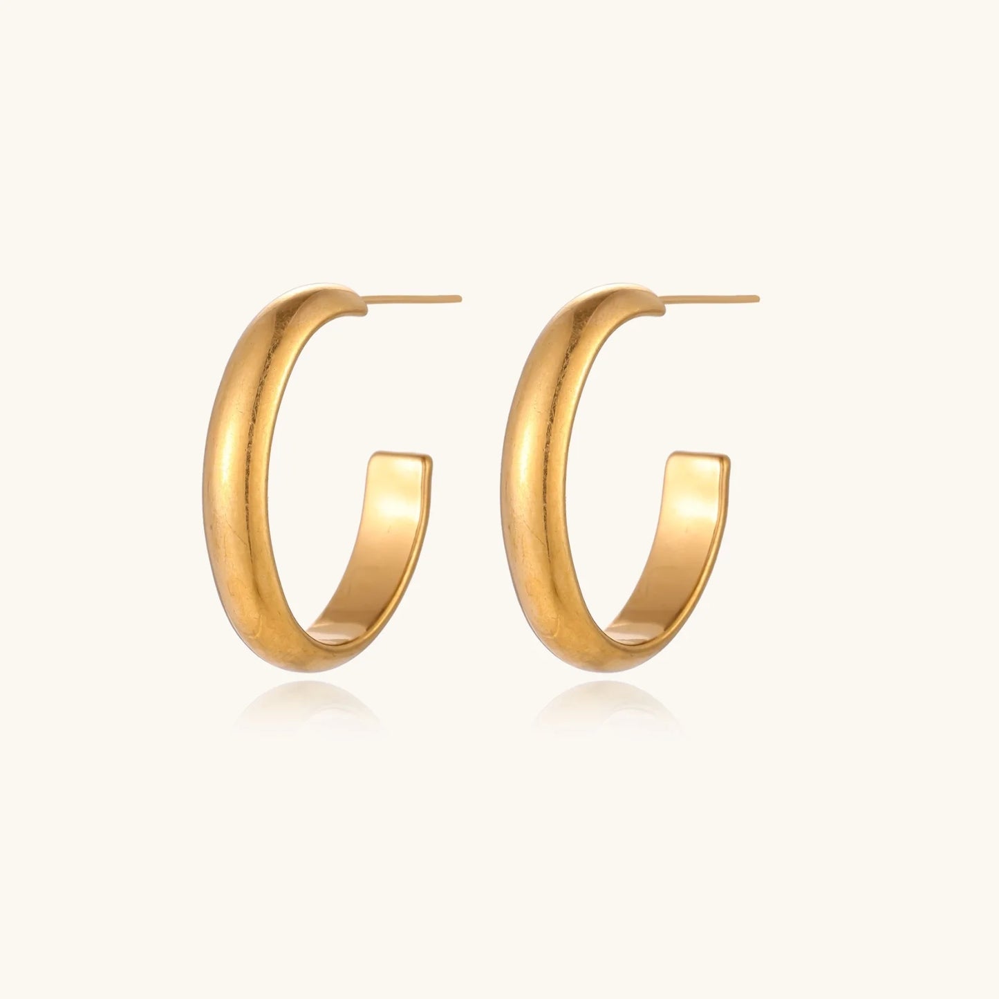 Chunky brushed gold hoop earrings in 14K plated stainless steel on cream background, front and side view.