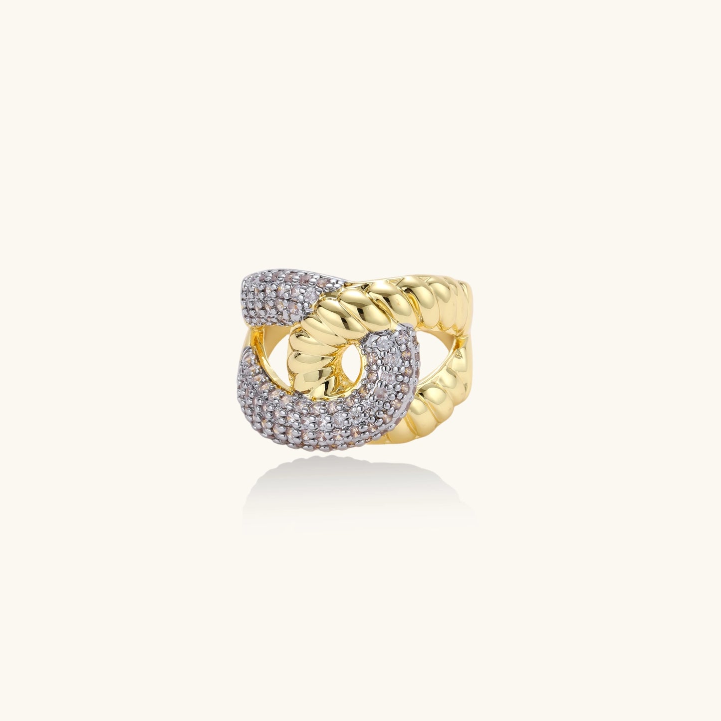 Chunky gold-plated chain-link ring with curved segments and sparkling zirconia crystals on neutral background